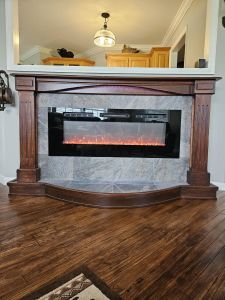 Custom-built cherry fireplace surround. Ambient lighting built-in with a raised hearth, ceramic tile and moveable.