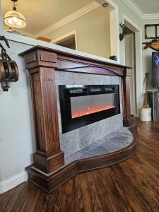 Custom-built cherry fireplace surround. Ambient lighting built-in with a raised hearth, ceramic tile and moveable.